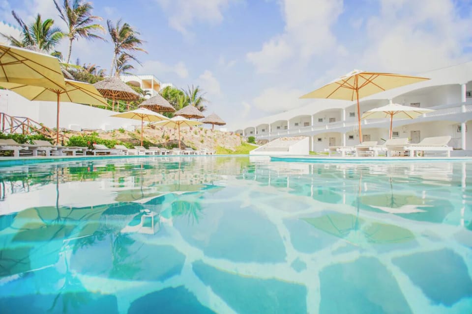 Dive into shimmering blue waters under breezy sun umbrellas
