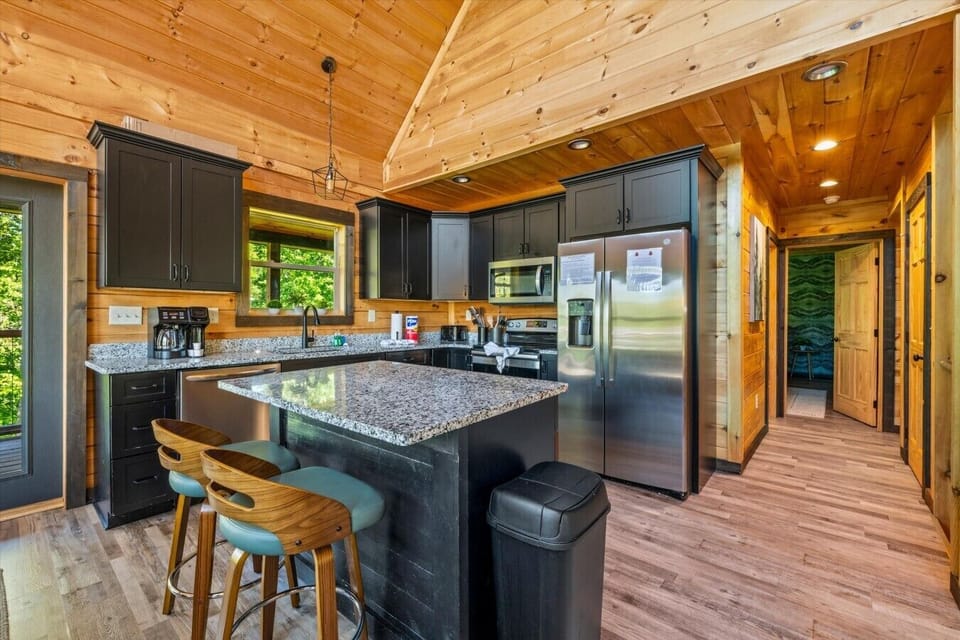 Prepare meals with ease in the modern kitchen featuring stainless steel appliances, granite countertops, and a convenient breakfast bar.