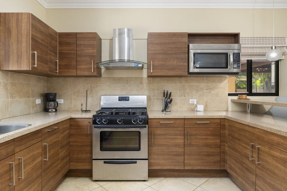 Modern kitchen with all the essentials, including a gas stove, coffee station, and ample prep space. Perfect for preparing breakfast to enjoy by the pool.