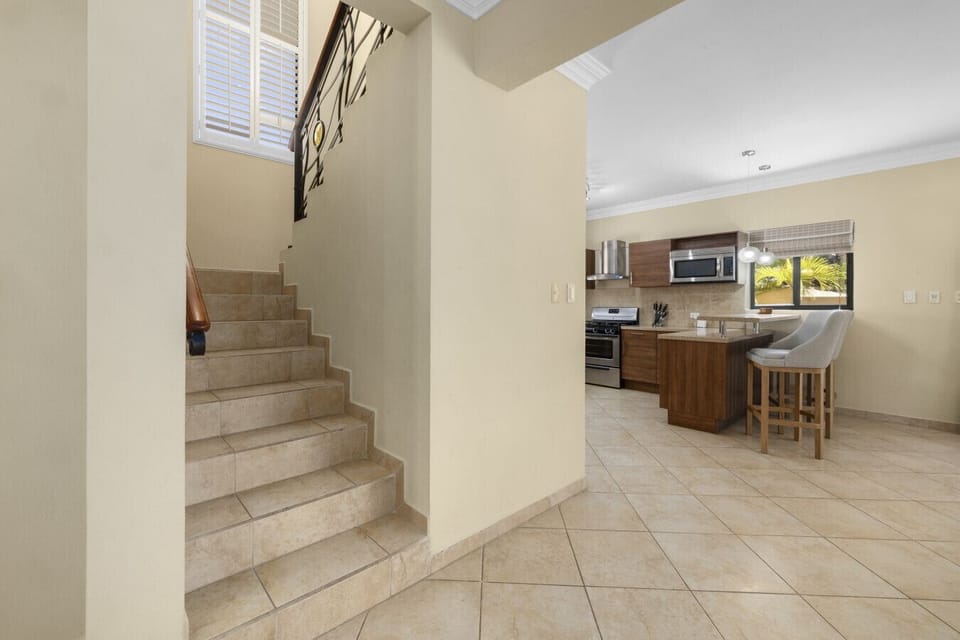 Easy access between the main floor and upstairs bedrooms. The open layout keeps the kitchen and social areas connected, while the stairs lead to your private retreat.