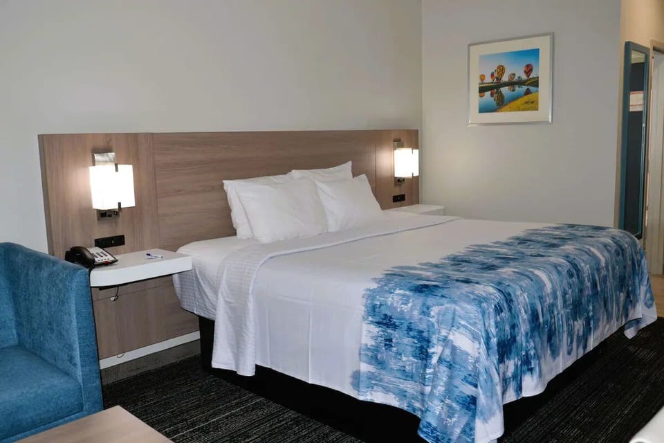 Unwind in crisp linens and a calm, modern room.