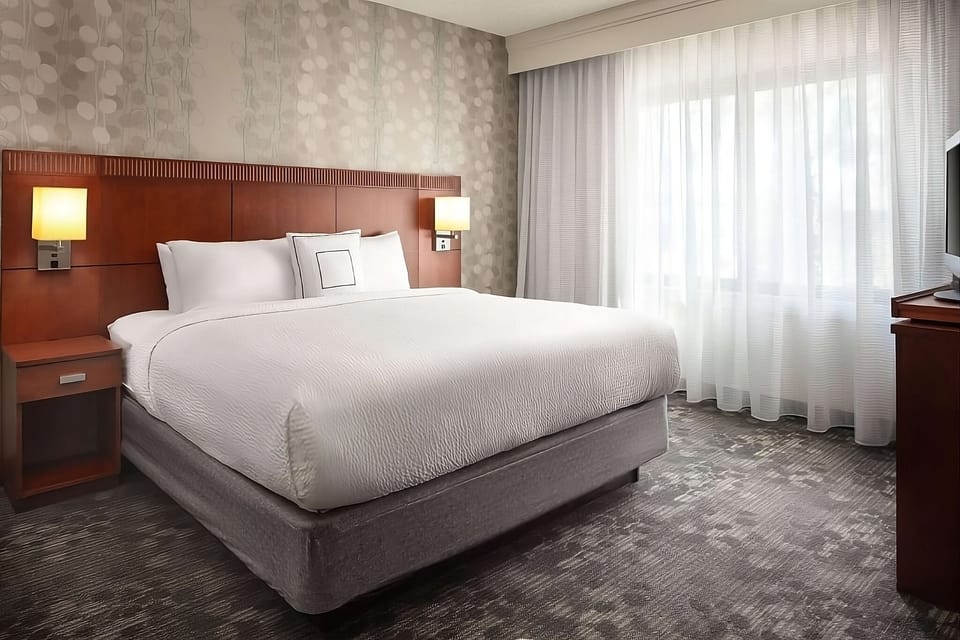 Unwind in a crisp king bed with soft daylight.