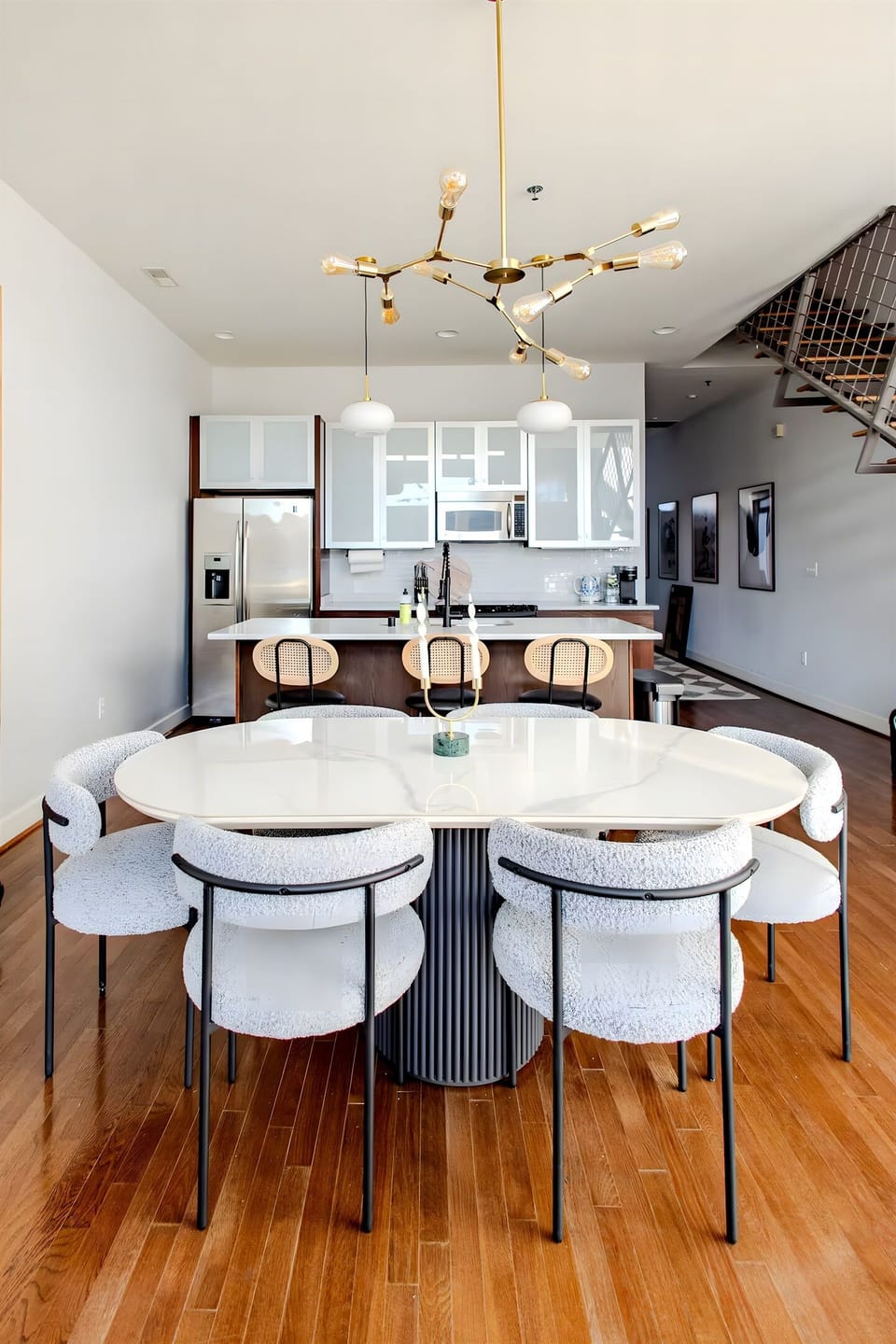 Enjoy a delicious meal at this stunning white marble dining table surrounded by chic curved chairs. The open layout makes it so easy to move from dinner to the kitchen.