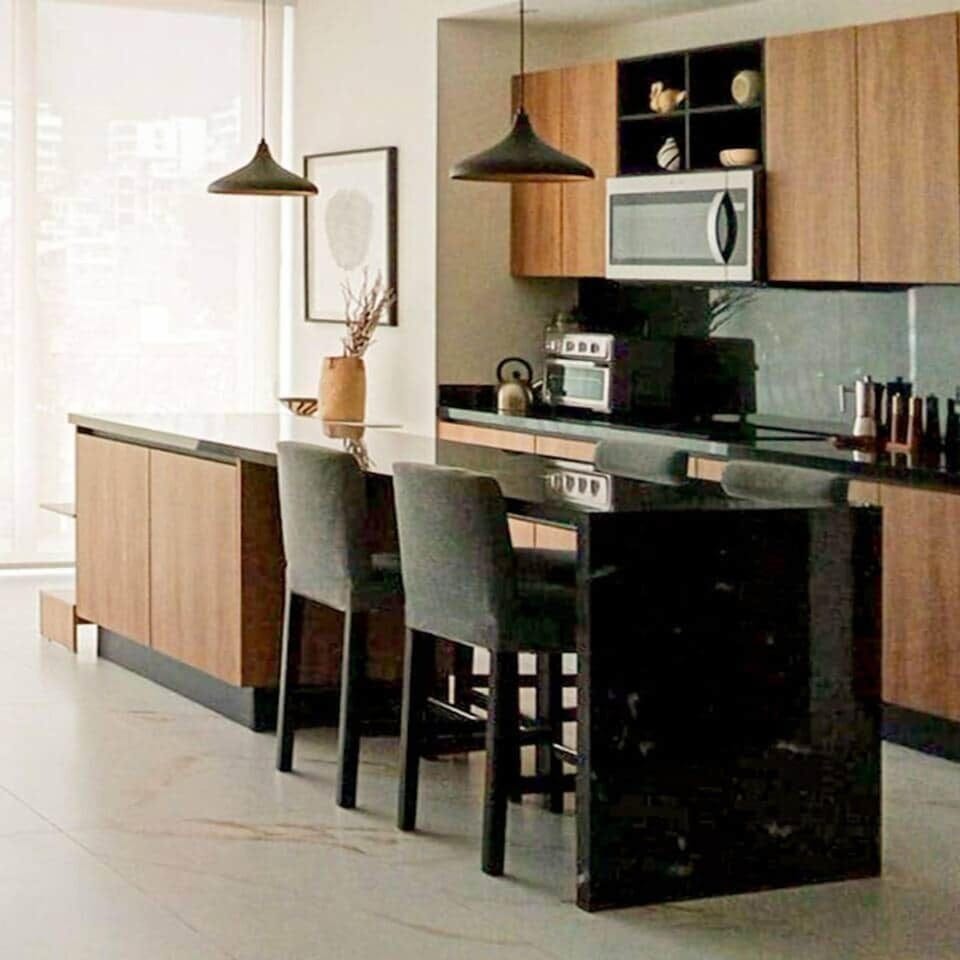 Stunning polished black granite waterfall island, doubles as a kitchen table, with four upholstered tall chairs