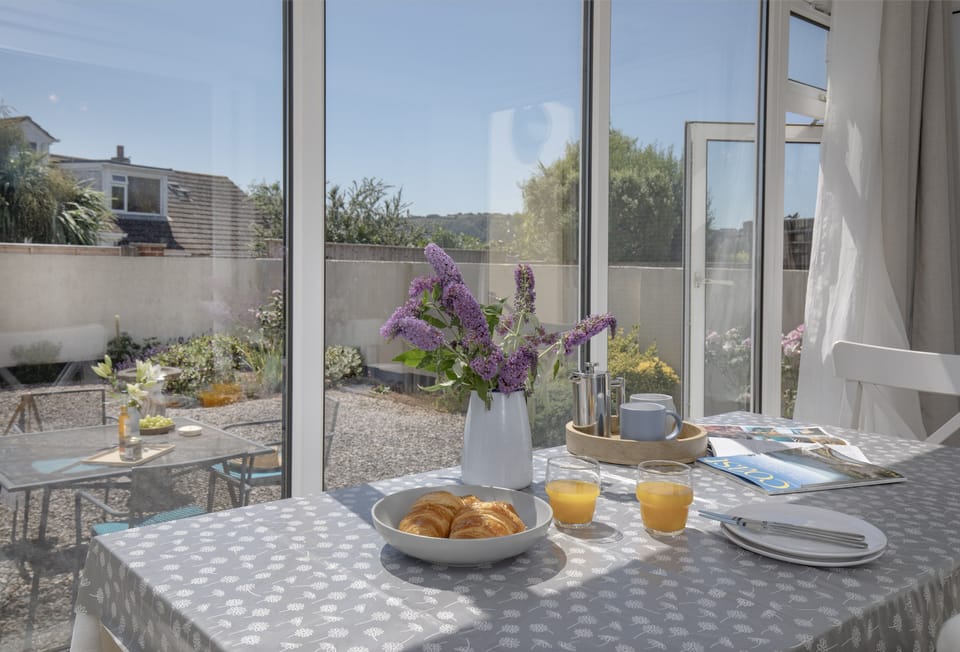 Avalon, Brixham: Conservatory dining area with glass doors opening directly into the garden.
