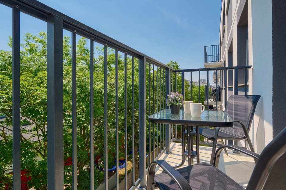 Balcony view with a charming seating area and lush greenery.

