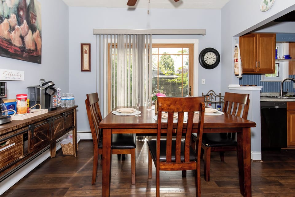 Gather around the warm wooden dining table for meals and memories, with natural light streaming through sliding doors leading to your private outdoor space.