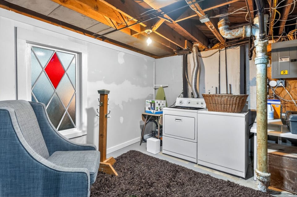 Bright and functional basement laundry room with a charming stained glass accent window.
