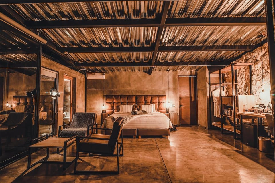 Unwind in a dramatic industrial-chic suite with warm ambient glow.