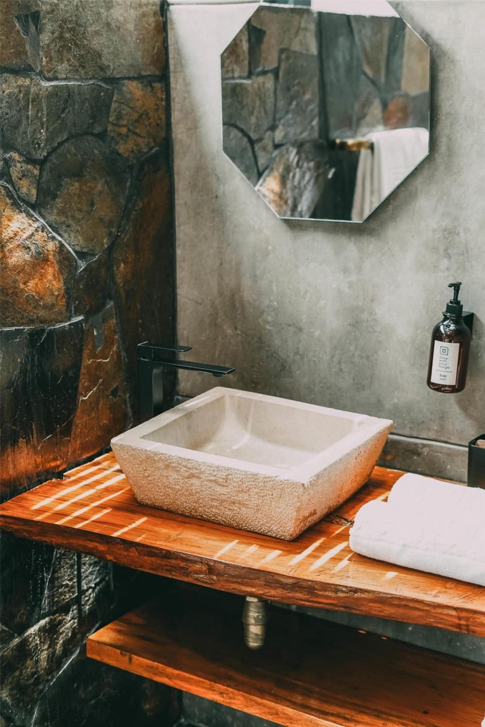 Start the day with a sleek stone basin and soft towels.