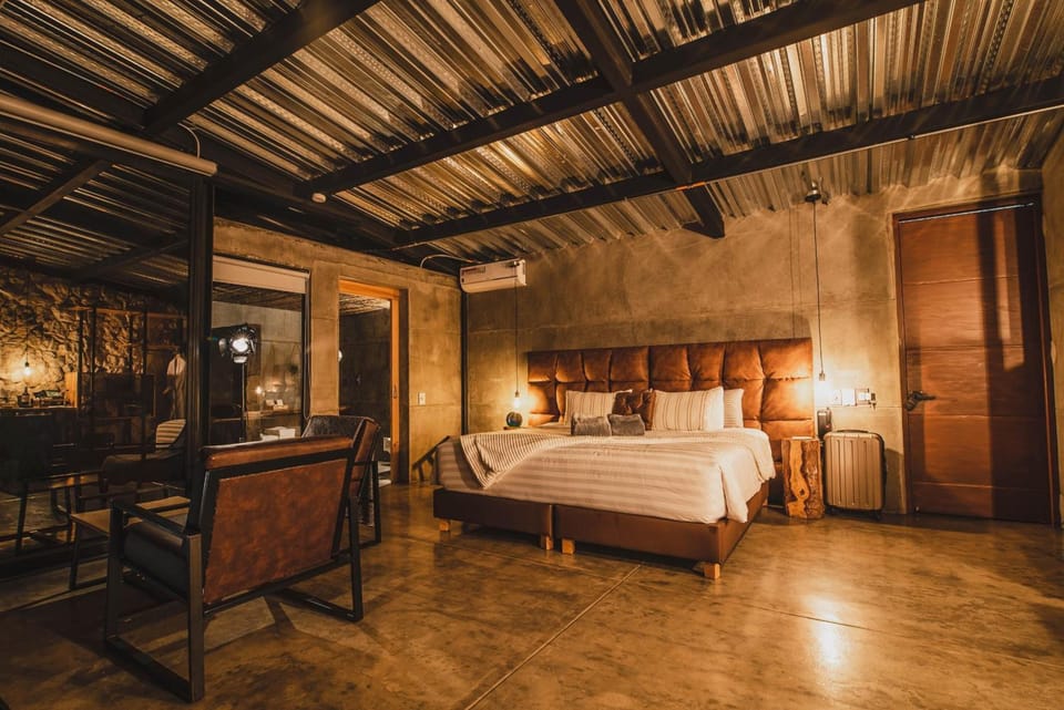 Unwind in a warm, industrial-chic suite with plush king bed.