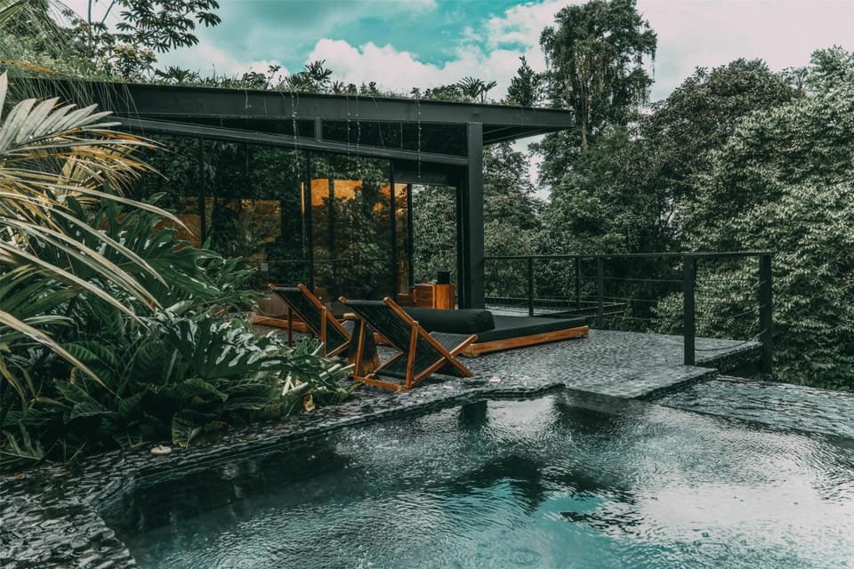 Lounge poolside beside sleek architecture tucked into the jungle.