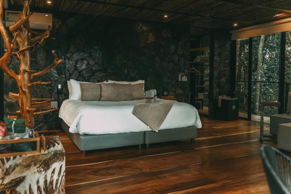 Unwind in a plush bed framed by rustic stone warmth.