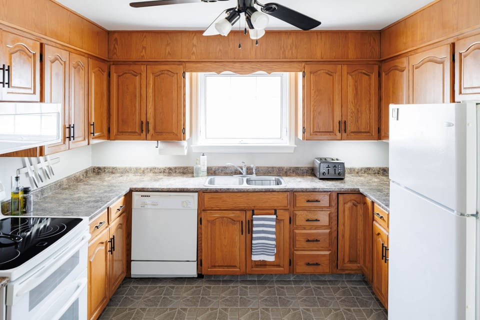 Bright, fully equipped kitchen with ample counter space and natural light.