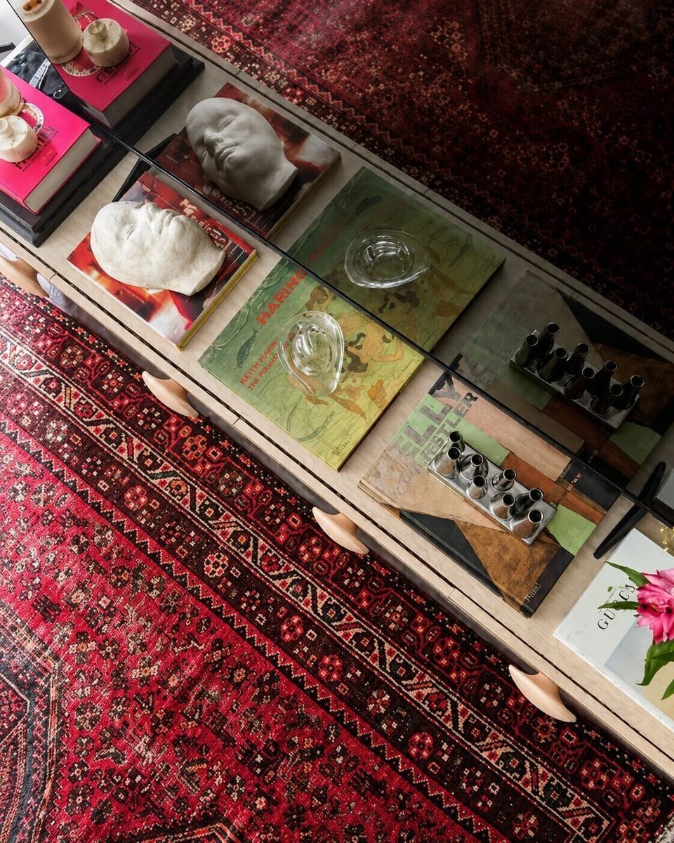 Glass coffee table with curated décor adds charm and boutique hotel style.