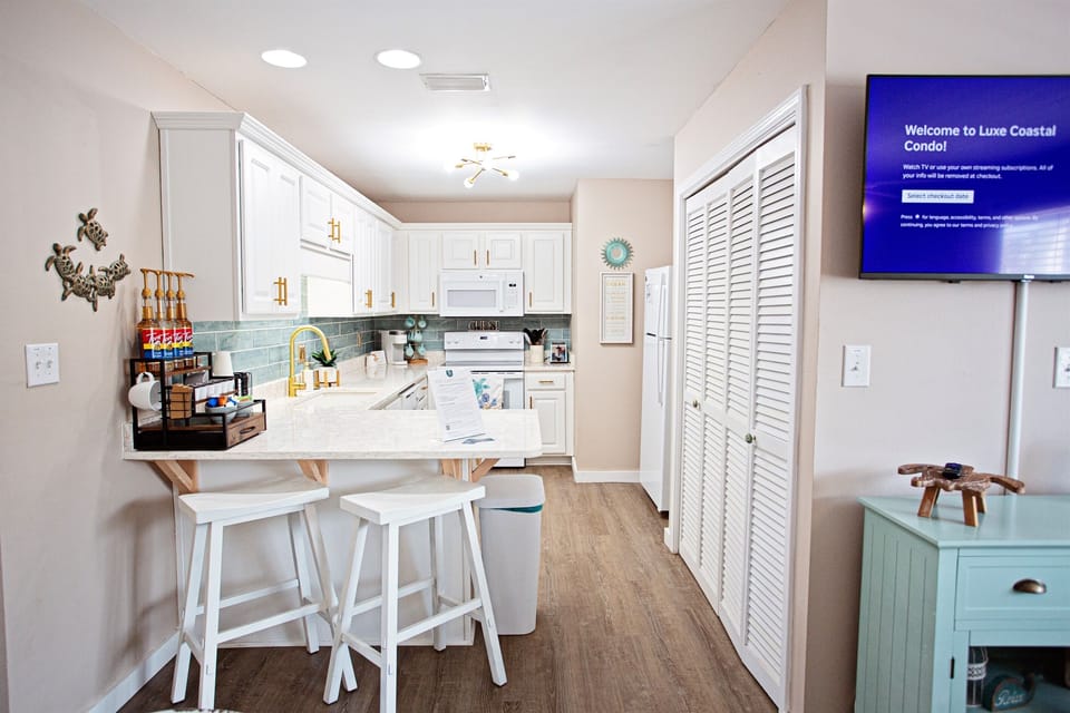 A chef’s dream by the shore. Our modern, fully-equipped kitchen features sparkling quartz counters, premium appliances, and a breakfast bar designed for social cooking.