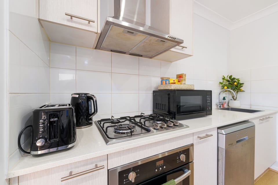 Bright modern kitchen with gas cooktop, dishwasher, and handy appliances