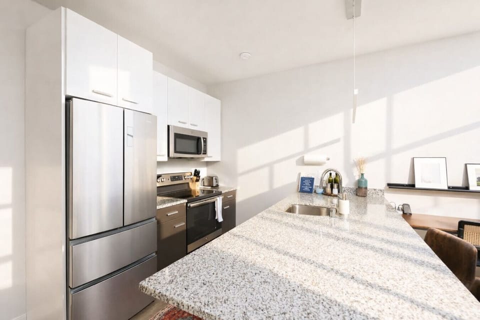 Chef’s kitchen featuring sleek granite countertops, stainless steel appliances, and a spacious island for morning coffee