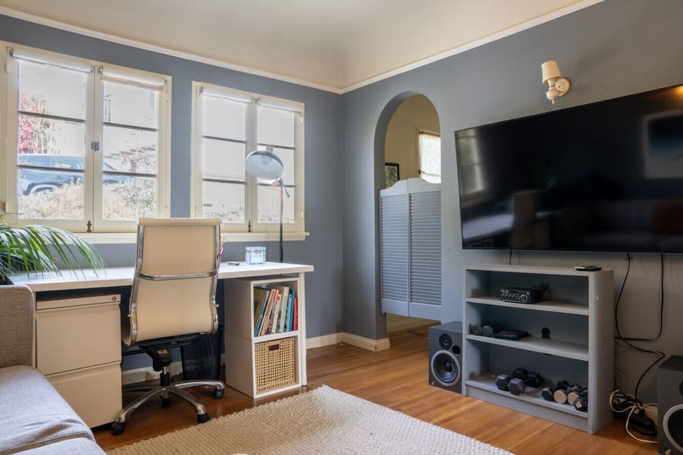 Comfortable area with a cozy couch, smart TV, and dedicated workspace—perfect for relaxing or getting things done.