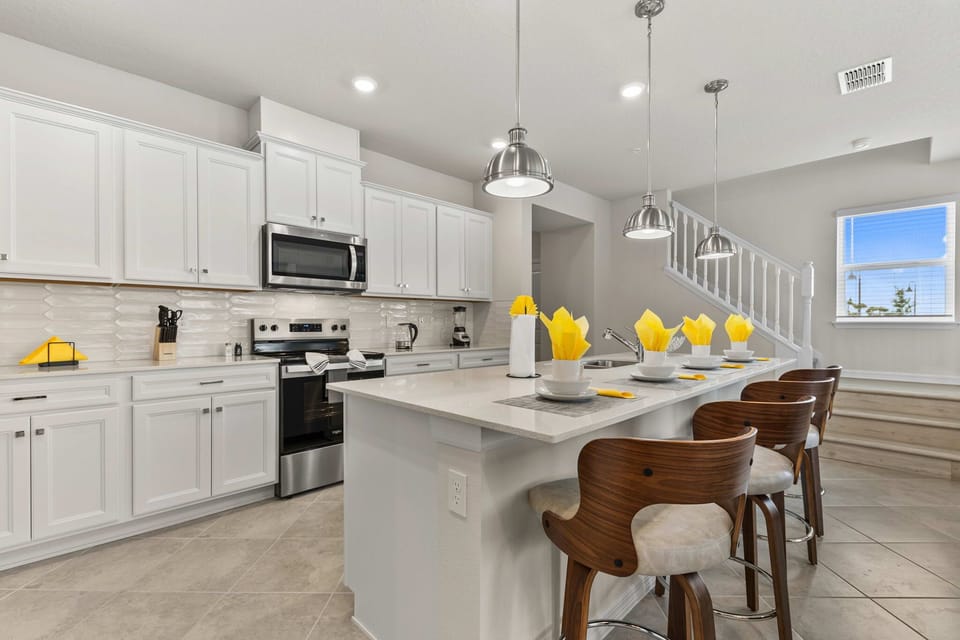 Gather at the sleek breakfast bar seating 4, with quartz counters and pendant lighting-your hub for snacks, chats, and vacation plans.