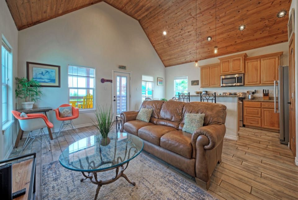 Cozy coastal living under soaring wood ceilings—open lounge and a fully equipped kitchen. (Cole's Cabin)