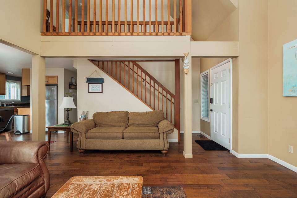 Relax in your spacious living room with soaring ceilings and warm wood accents that create an inviting atmosphere for memorable gatherings.