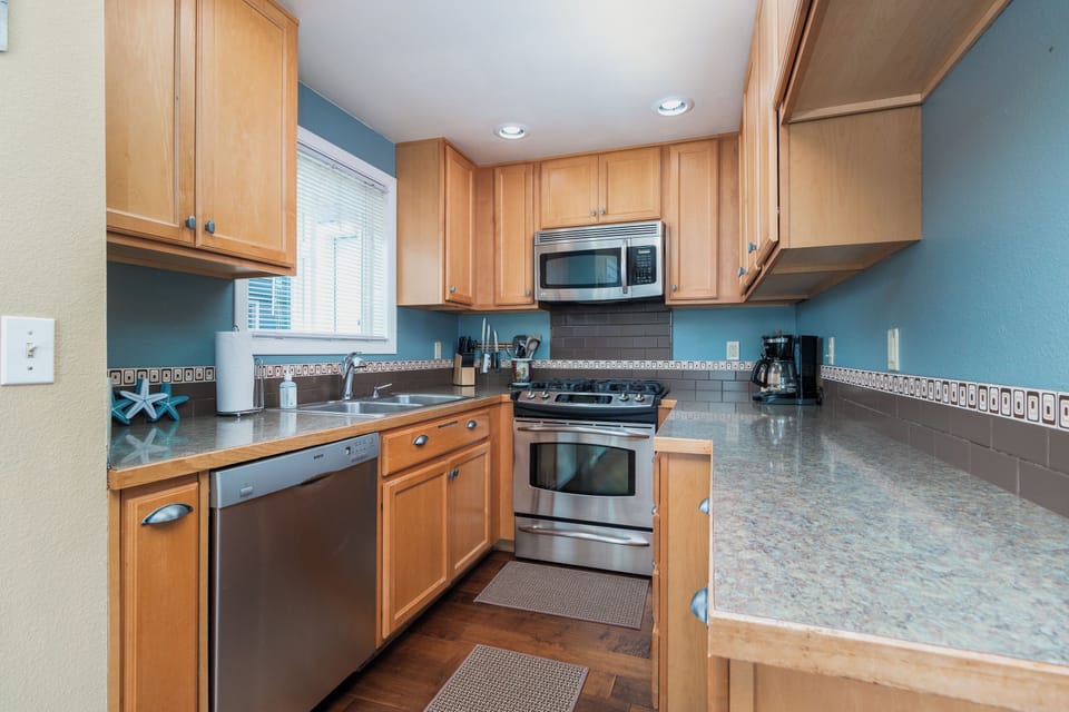 Your spacious kitchen features granite counters, stainless steel appliances, and plenty of cabinet storage for preparing memorable meals during your stay.