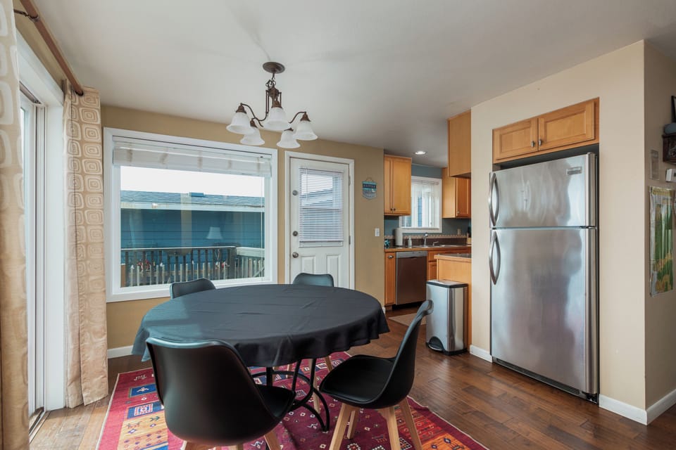 Your open-concept kitchen and dining space features modern appliances and a cozy breakfast nook with lake views through large windows.