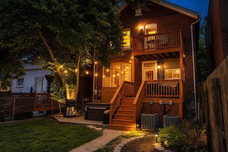 Cozy backyard retreat with deck, patio, and glowing string lights
