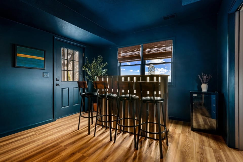 Bar area with seating and beverage fridge—perfect for drinks, snacks, and keeping everything close during the game or movie, just steps  from the hot tub, fire pit, sauna, and game room—this space connects it all for easy indoor-outdoor living.
