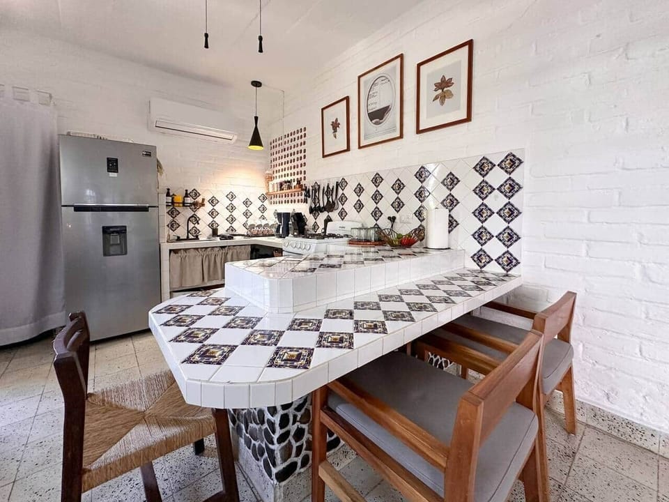 Two-tier tiled counter serving as both kitchen workspace and dining table — a functional, space-saving setup for cooking and shared meals.
