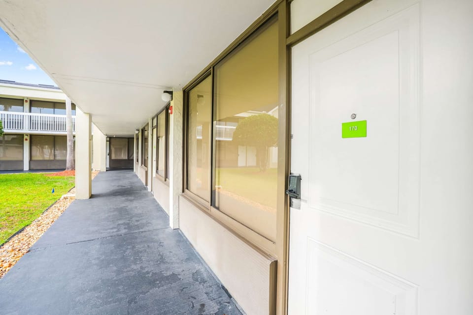 Exterior corridor view of the unit entrance with large windows and secure door access.