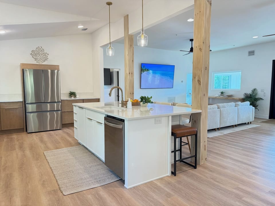 Open concept luxury living featuring one of two 85" smart TVs at the house