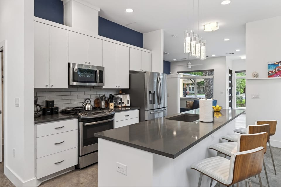 Modern kitchen with sleek finishes, large island seating, and stainless steel appliances for easy entertaining.