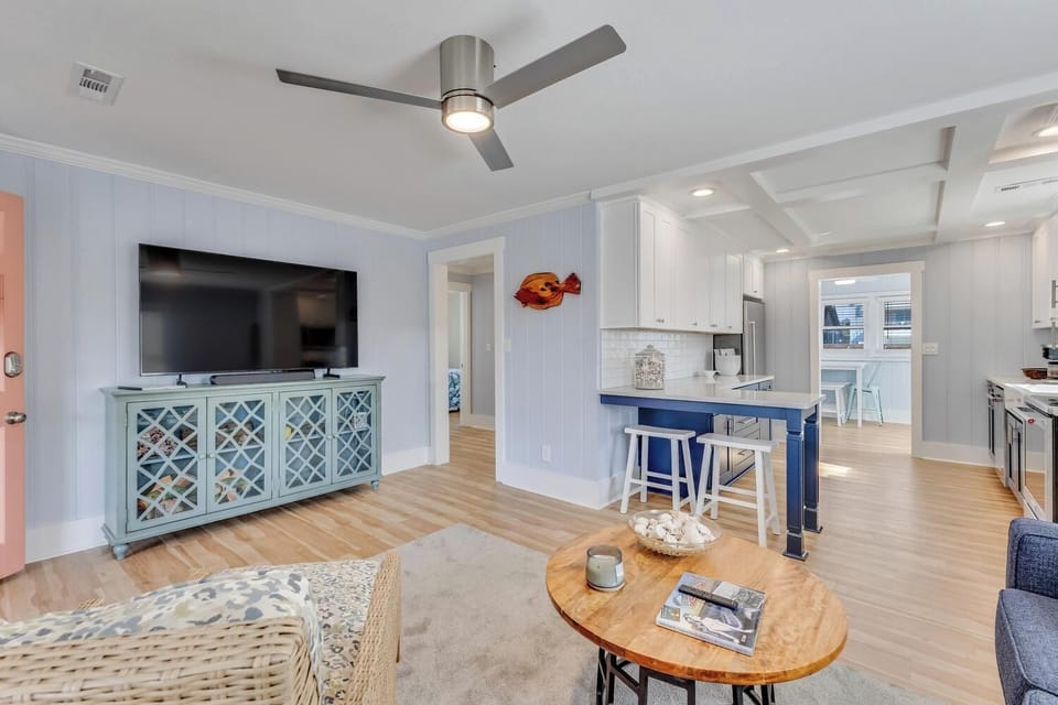 Relax in your bright, airy living space with coastal charm, modern kitchen, and comfortable seating perfect for unwinding after beach days.