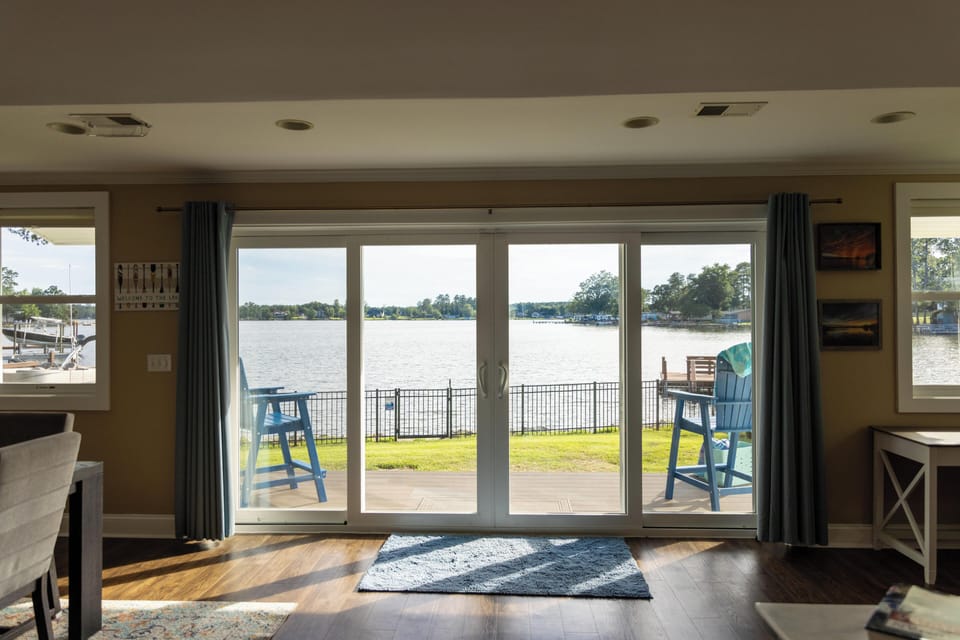 Bright waterfront living room with patio access and stunning lake views