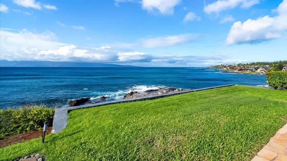 Stunning oceanfront grounds showcase pristine blue waters and dramatic coastline views stretching to the horizon.