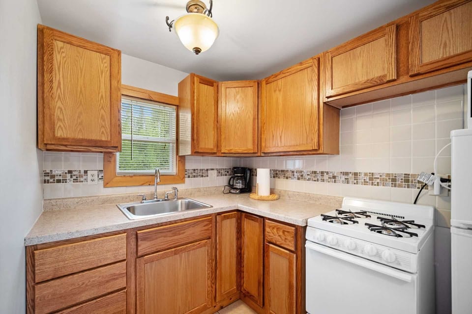 Fully stocked kitchen with stove, fridge, coffee maker, and cookware for meals in