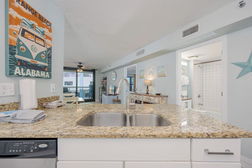 Granite counter in the kitchen offers space for meal prep as you plan your day by the shore