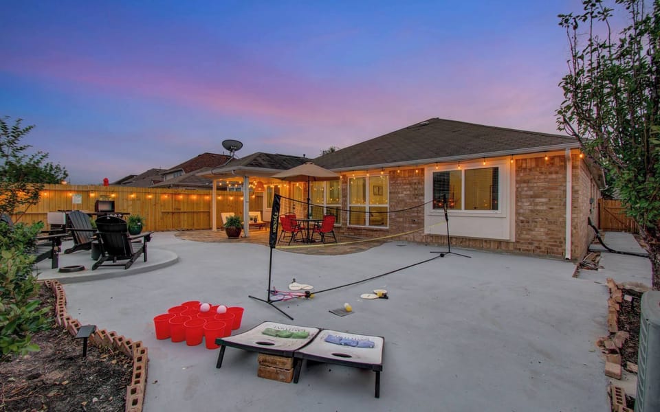 Spacious backyard hangout with string lights, fire pit, and games—perfect for sunset fun and group gatherings.