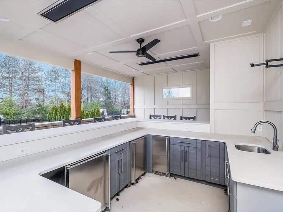 Outdoor kitchen w/ grill, counter space & bar seating, perfect for open-air cooking