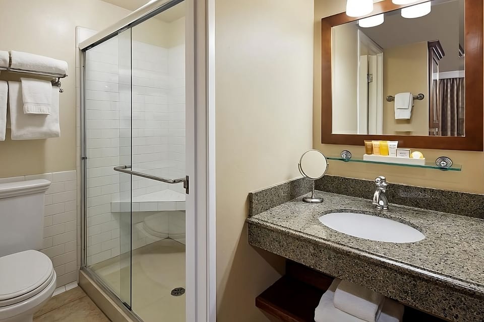 Refresh under a sleek glass shower with bright lighting.