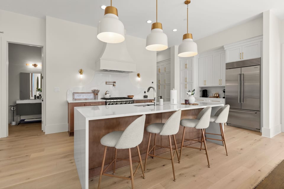 Gourmet kitchen with quartz island, pro range & chic brass lighting