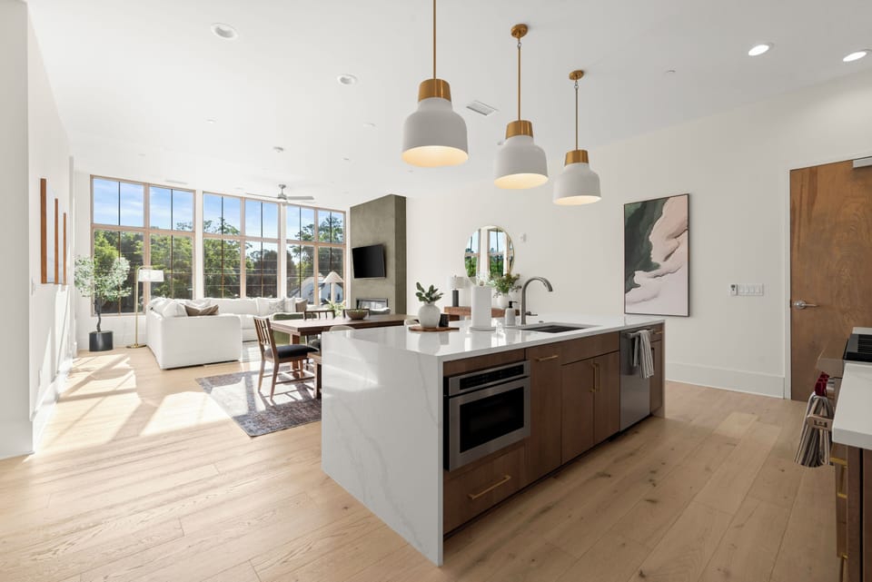 Bright open-plan kitchen/living with waterfall island and big windows