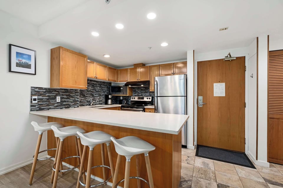 - Modern kitchen with stainless steel appliances and  expansive counters - Stylish backsplash and lighting for a warm inviting atmosphere - Perfect for cooking meals or enjoying morning coffee before the slopes