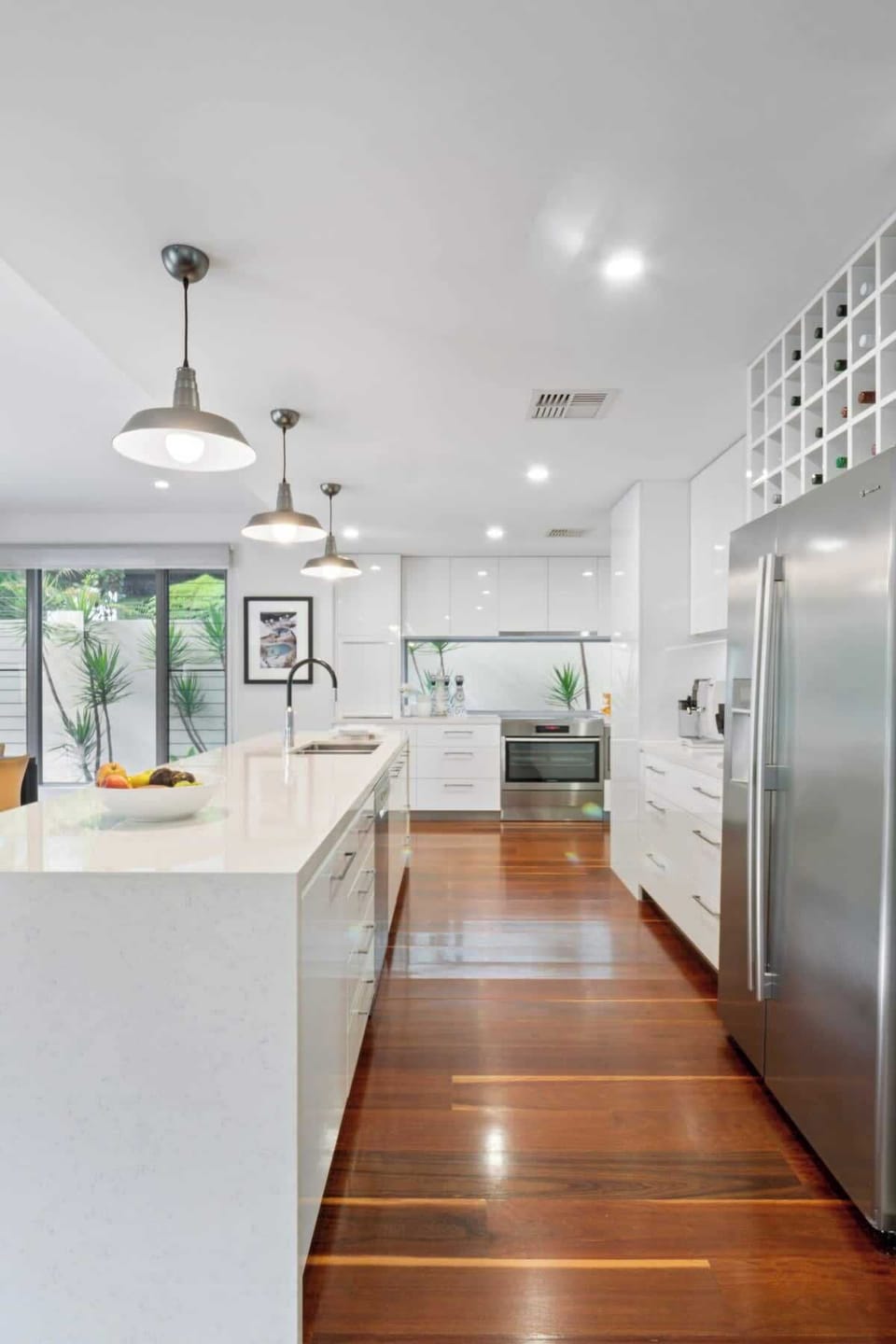 The gourmet chef's kitchen with a waterfall-edge centre island, a long breakfast bar, a butler's pantry and a suite of stainless steel appliances.  