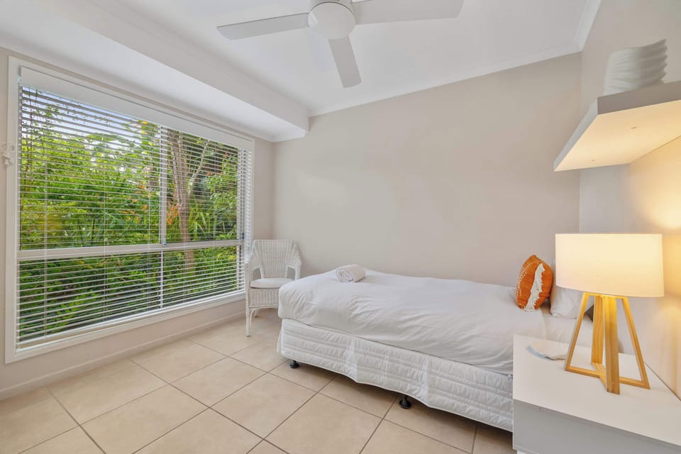 The third bedroom is set with a single bed and ceiling fan.
