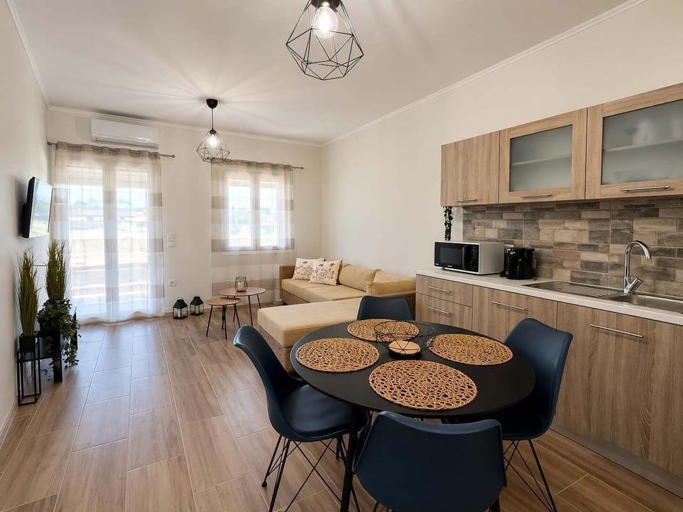 Casa Plati 1: The open-plan living and kitchen area feels bright and practical, with a dining table and seating arranged for easy meals and relaxed time indoors.