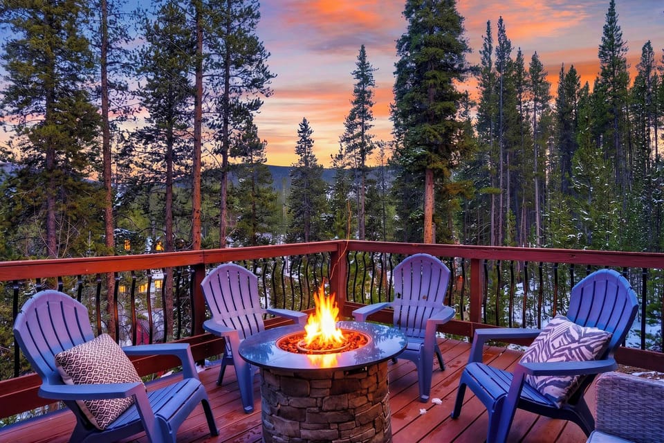 Fire pit deck with Adirondack seating and stunning sunset views over the forest.