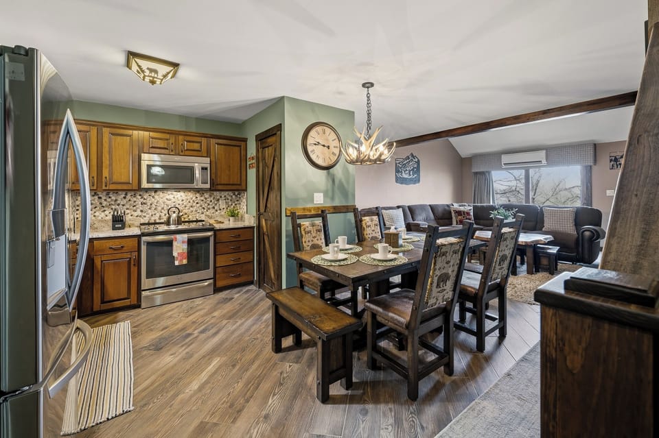 Warm, cabin‑style kitchen and dining area with wood accents, modern appliances, and a cozy open layout.
